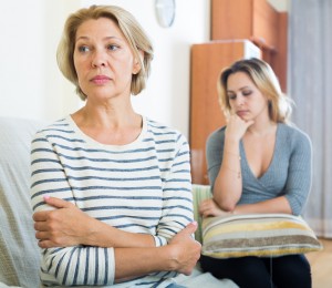 Upset young woman and senior mother having bad argue indoor